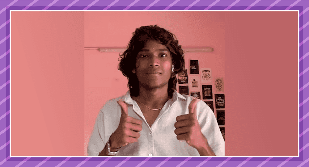 Karthi showing a thumbs up sign in a pink background.