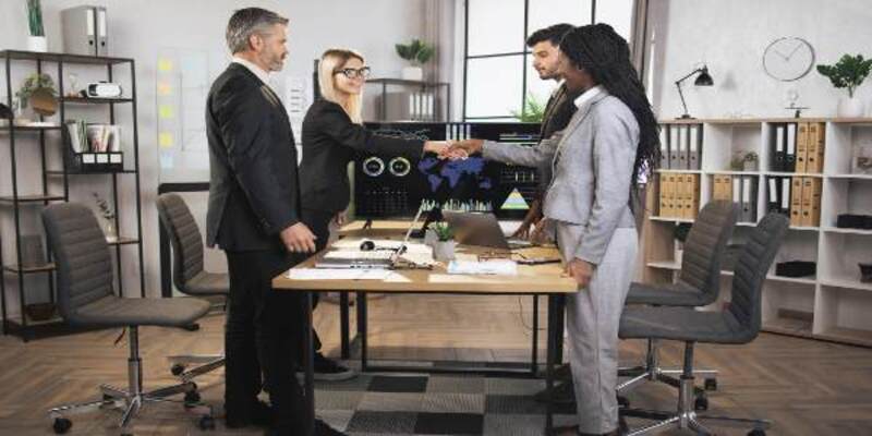 four businesspeople shaking hands with each other