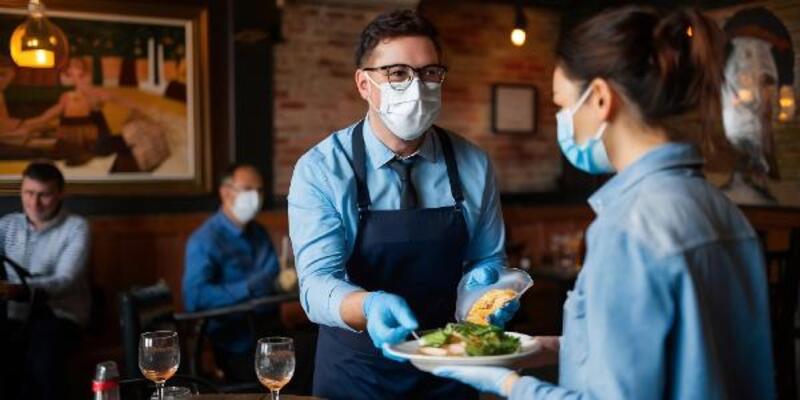 A man and woman are preparing food in a restaurant