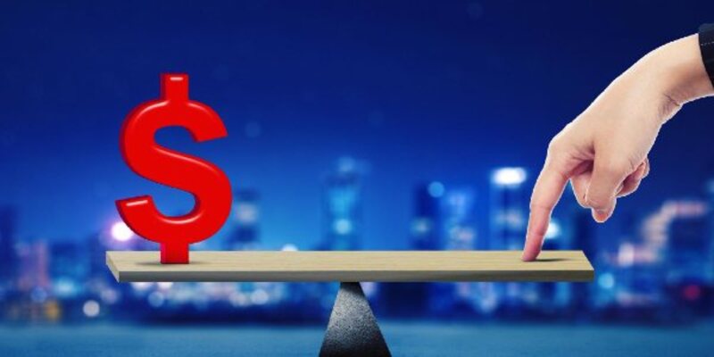 Businessman hand balancing dollar symbol on scale