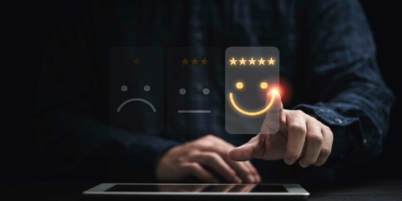 Businessman using smartphone for select smiley face icon for client evaluation and customer satisfaction