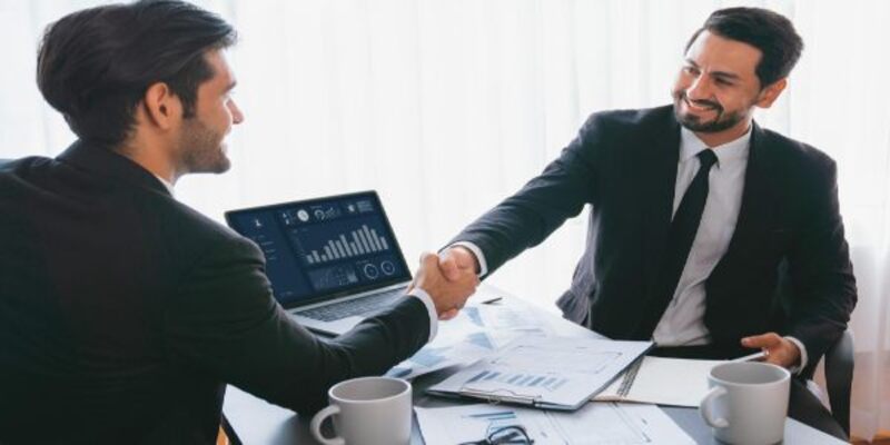 Two men shaking hands, one of which is a business model