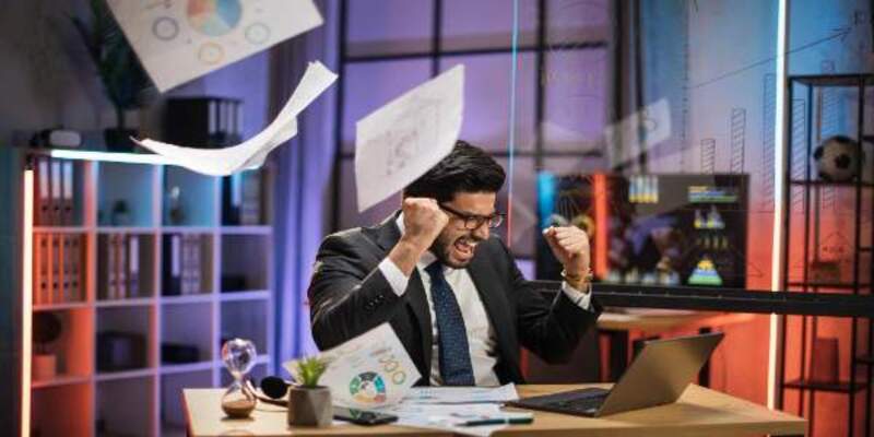Over joyed indian bearded businessman in suit getting good news looking on laptop screen