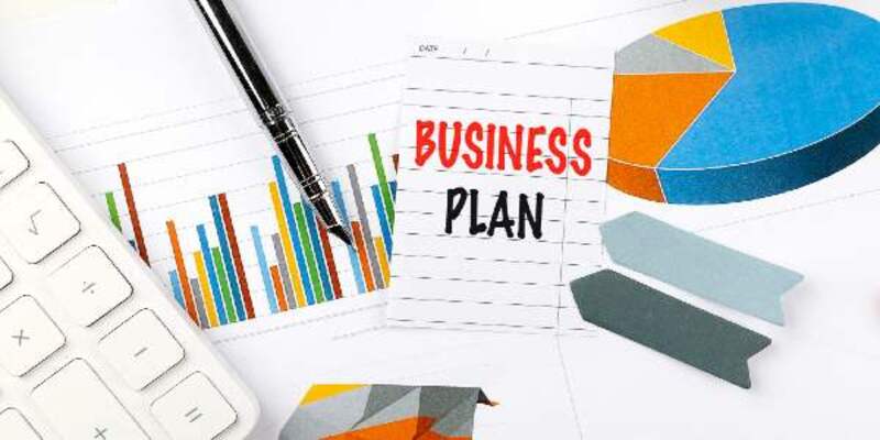 Business plan concept with charts pen calculator and note on a white desk