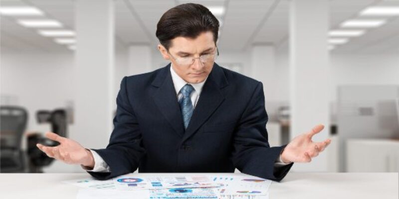 Young businessman sitting at desc with social network icons