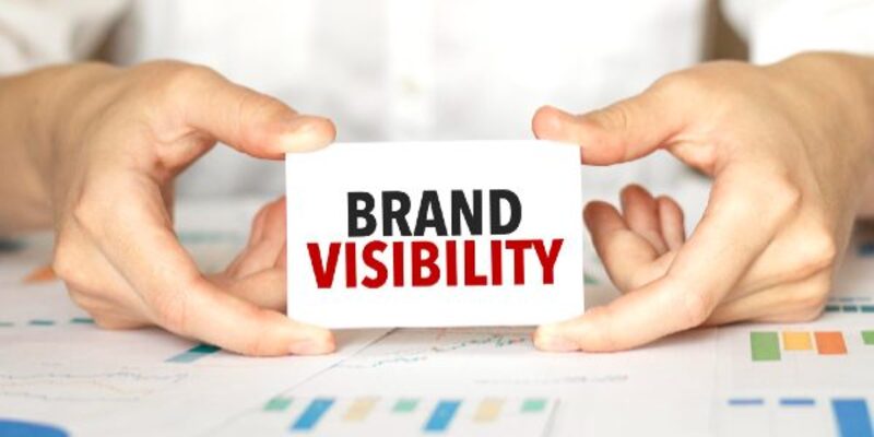Businesswoman holding a card with text brand visibility