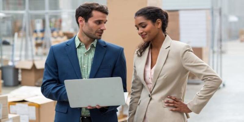 Warehouse managers discussing with the laptop