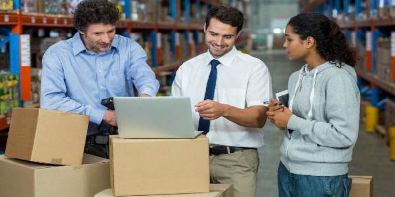 Worker team looking a laptop put on a cardboard box