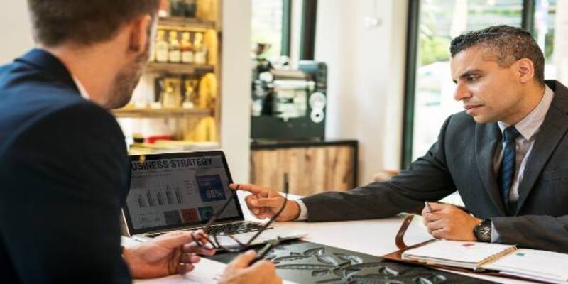 Two businessmen discussion at cafe meeting laptop concept