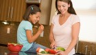 A woman and a child chopping fresh vegetables