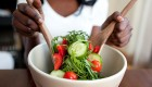 A woman mixing a salad in a bowl