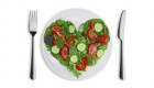 Heart shape of various vegetables and herbs on white plate