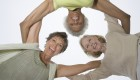 Three senior women embraced in a huddle, looking down at camera