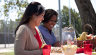 A pair of women sharing a meal together outside at a park