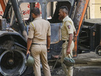 Nagpur: Police personnel near charred remains of a vehicle, a day after violence broke out following an agitation by a right-wing group demanding removal of Aurangzeb's tomb, in Nagpur.