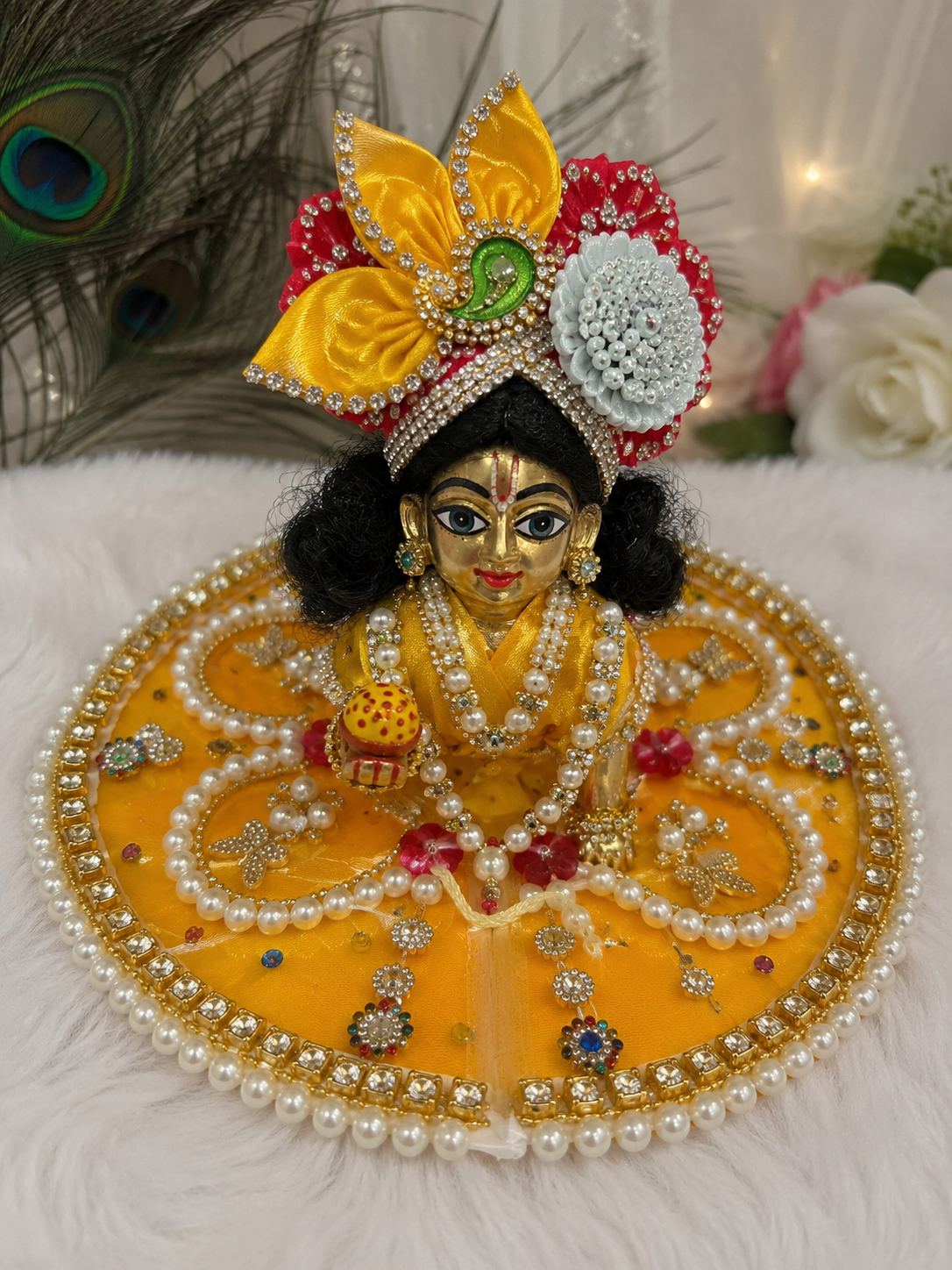 This is a yellow handcrafted Laddu Gopal Poshak adorned with pearl, stone, and butterfly embellishments.