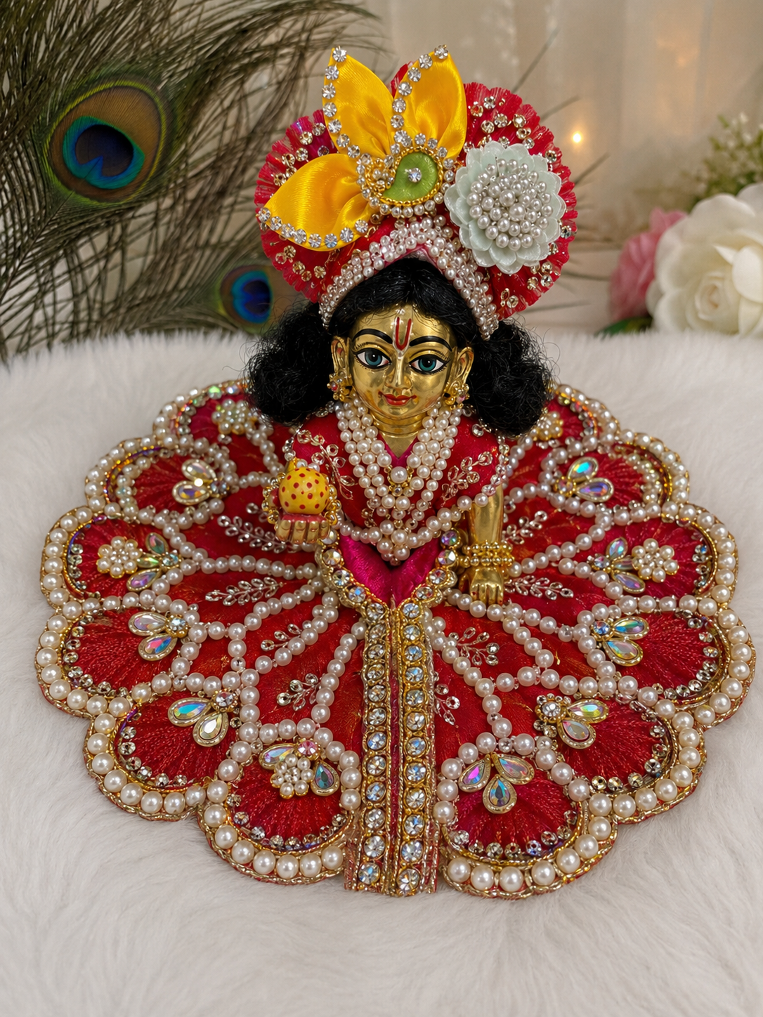 This is a heavily embellished, circular red velvet poshak for a Laddu Gopal idol.