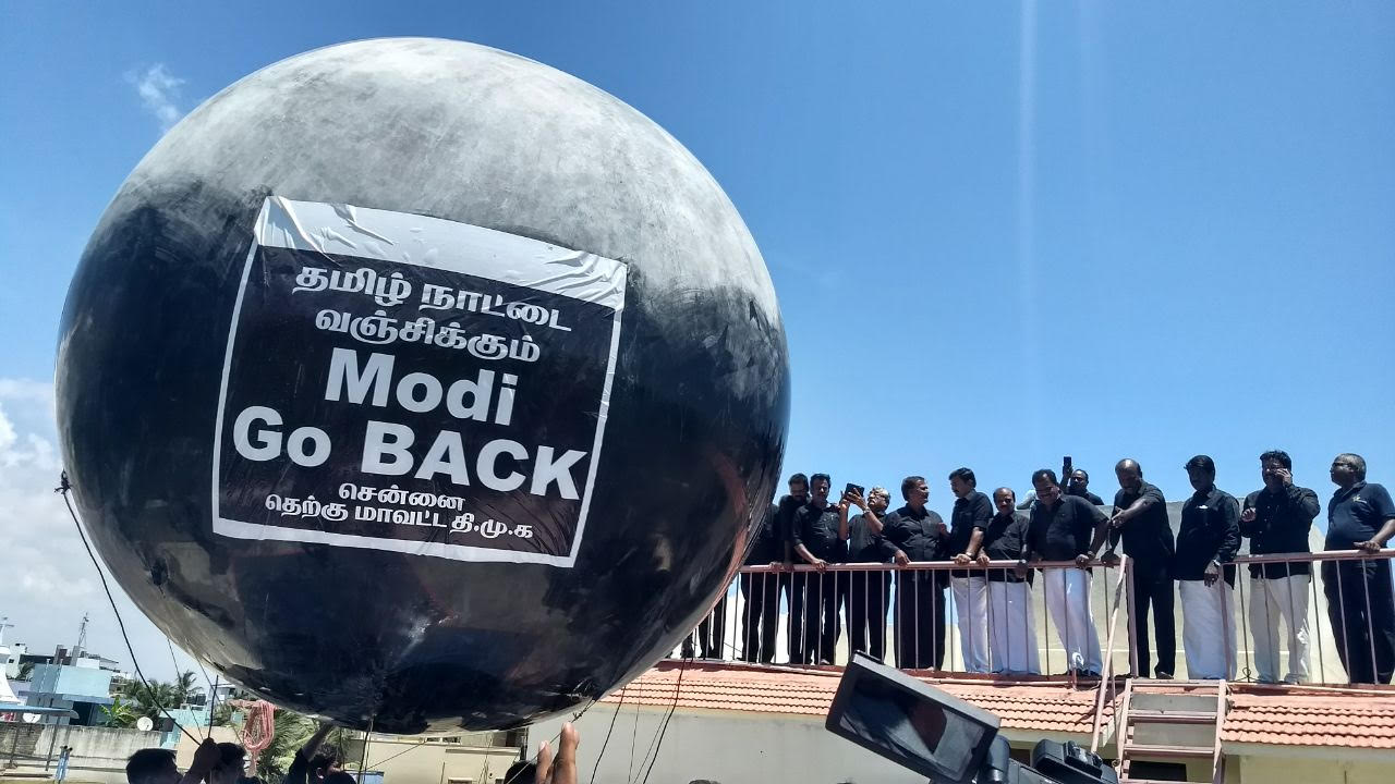 A giant black balloon that says Go Back Modi