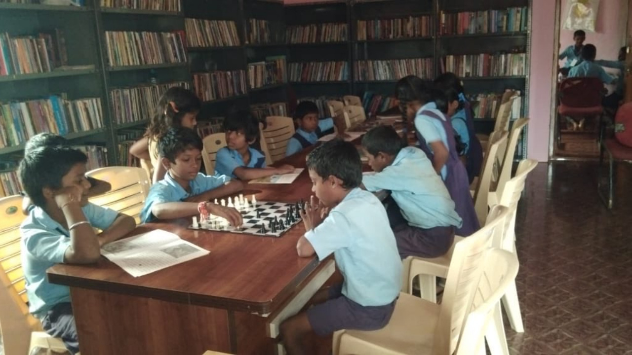 Karnataka rural libraries, children reading books and playing chess Karnataka rural libraries, children reading books and playing chess
