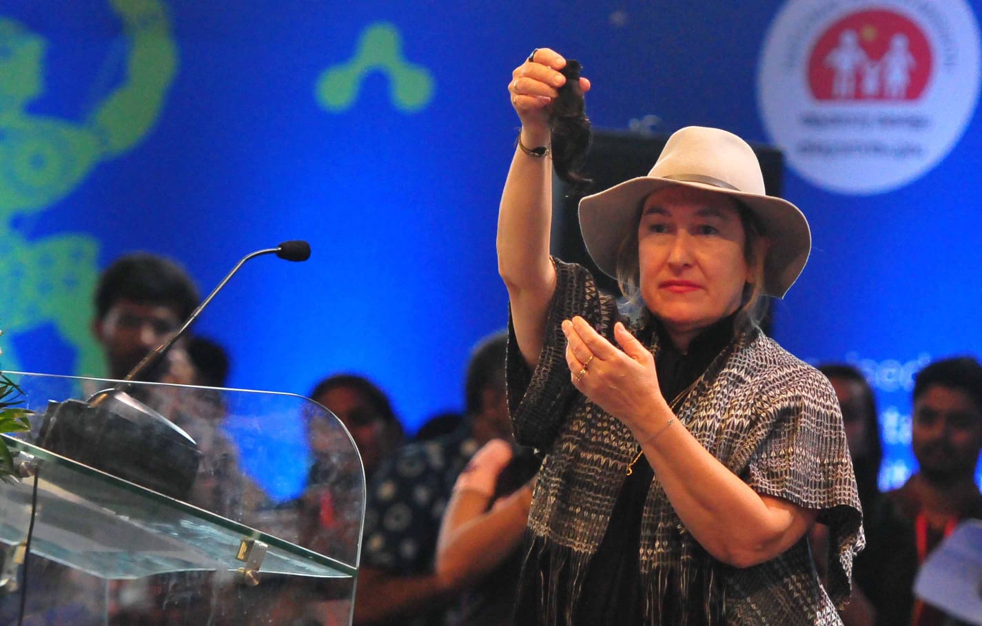 Greek filmmaker Athina Rachel Tsangari holds up a lock of hair of her Iranian counterpart Mahnaz Mohammadi at the inaugural of IFFK 2022.