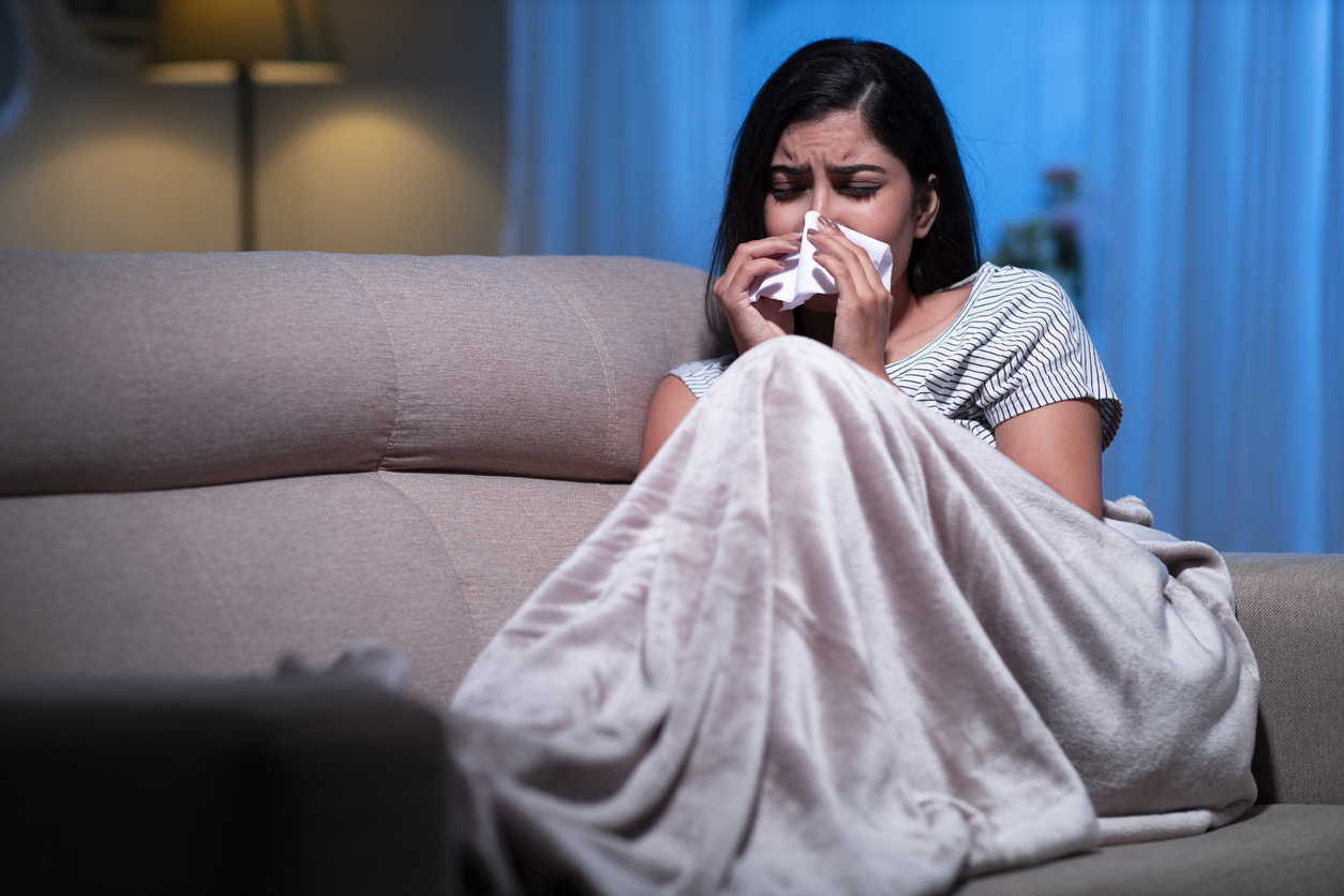 young women sick suffering from cold sitting on sofa Montelukast runny nose asthma