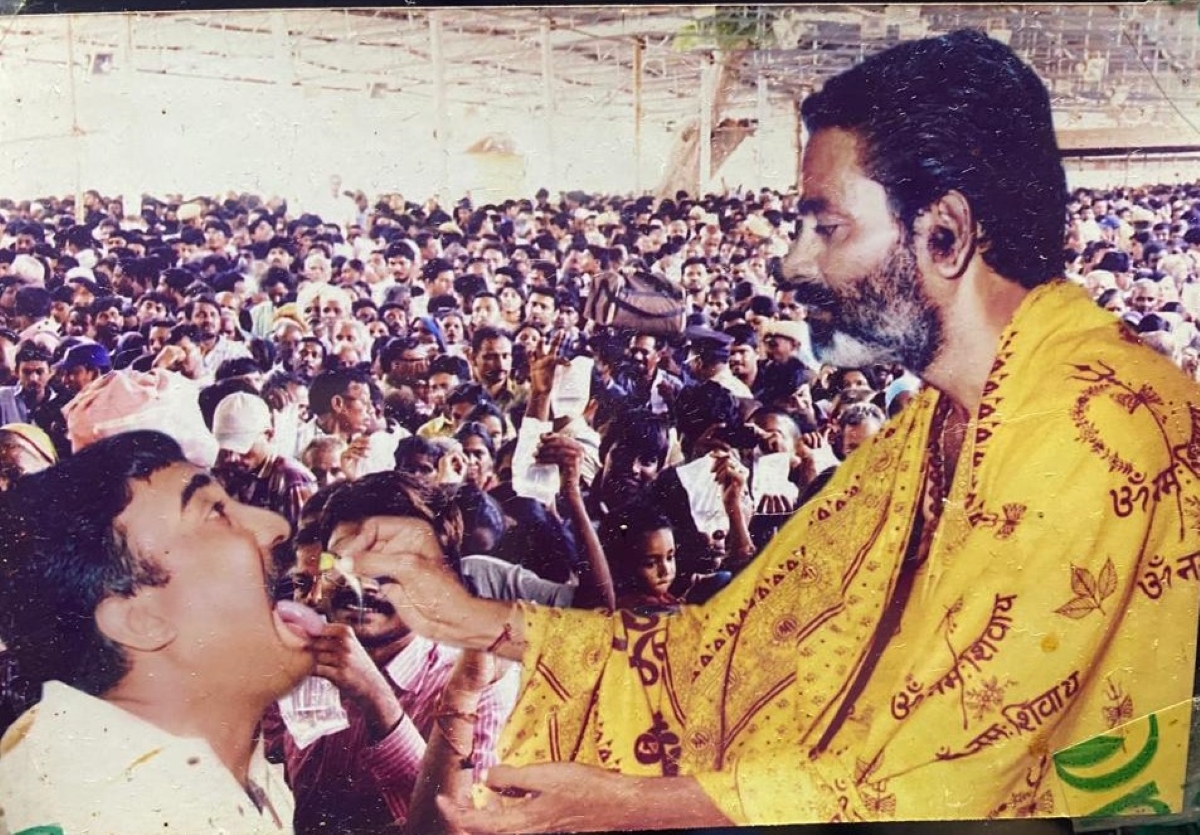 Bathin Harinath Goud making a patient gulp down fish prasadam Bathini Harinath Goud feeding the prasadam to a patient. (Supplied)