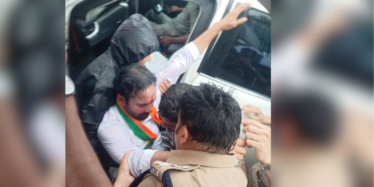Police detaining Kishan Reddy. (Twitter) Telangana BJP chief Kishan Reddy prevented by police from visiting housing project site; sits on road in protest