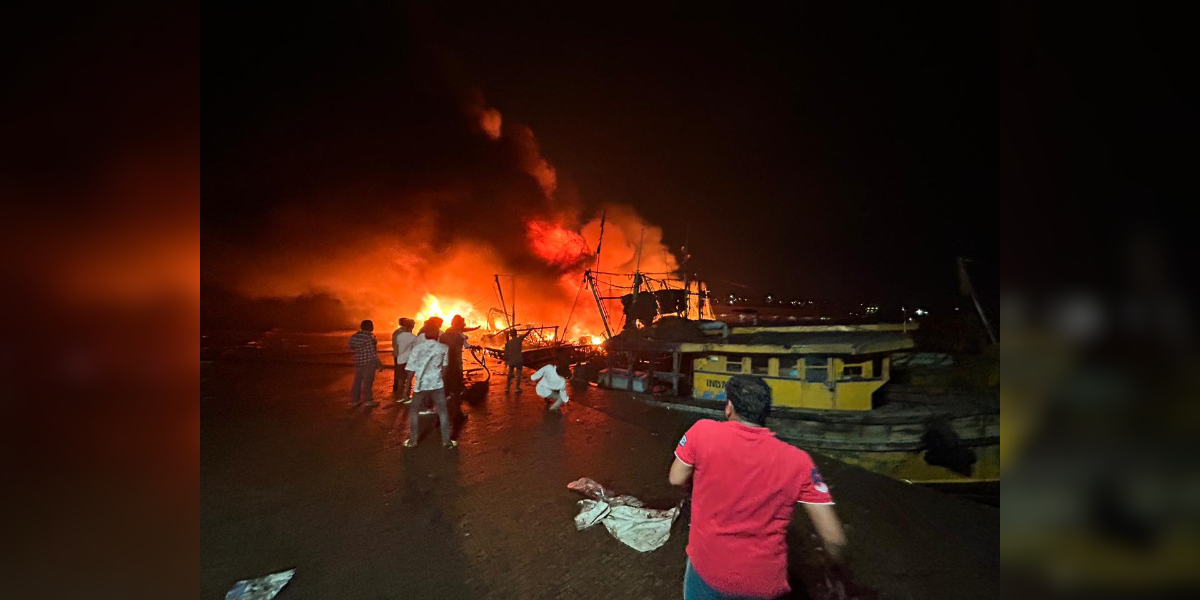 Fishermen attempting to contain the fire at Visakhapatnam Fishing Harbour. (X)