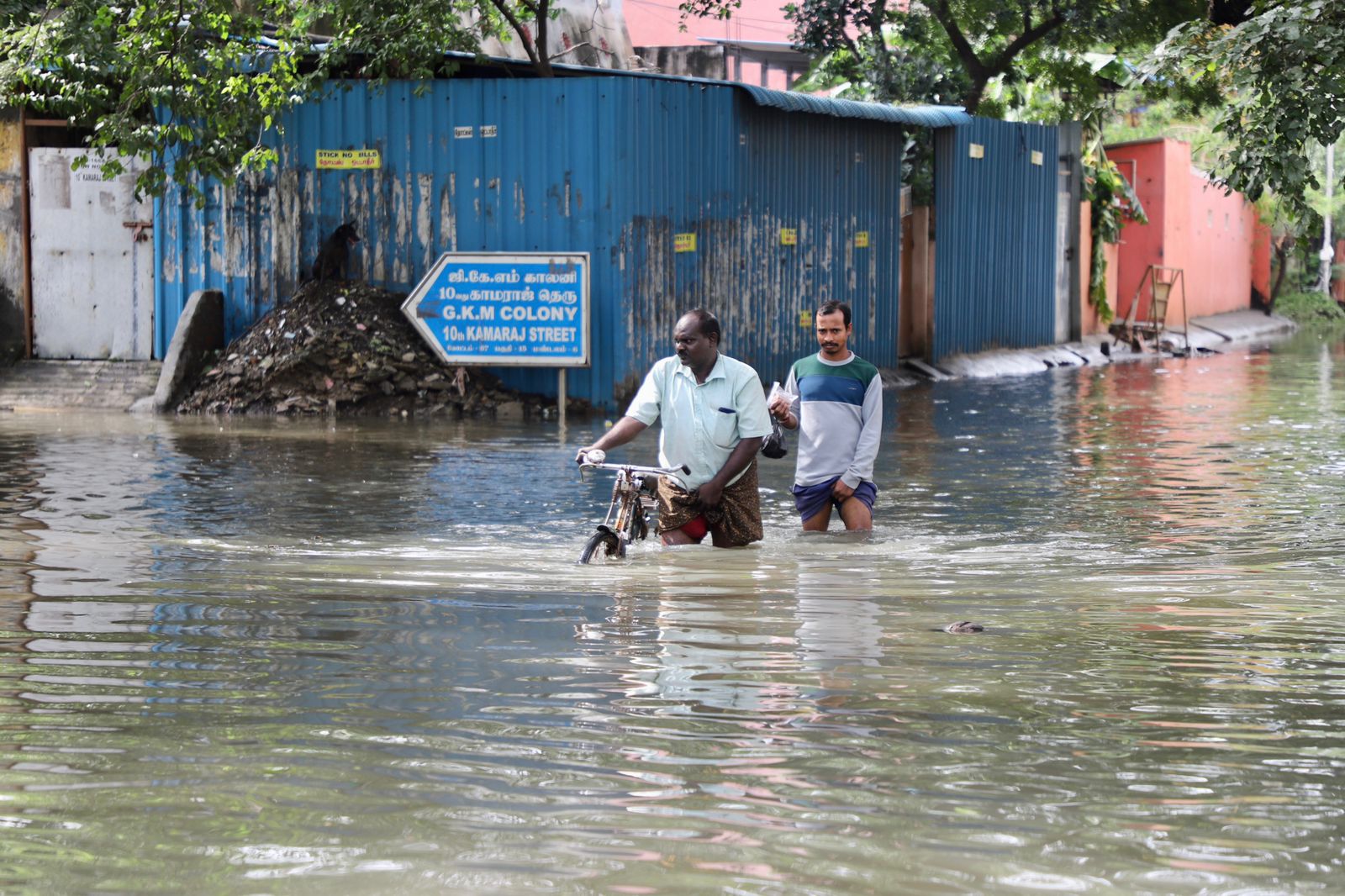 Two people finding their way through the waterlogged road. Two people finding their way through the waterlogged road.