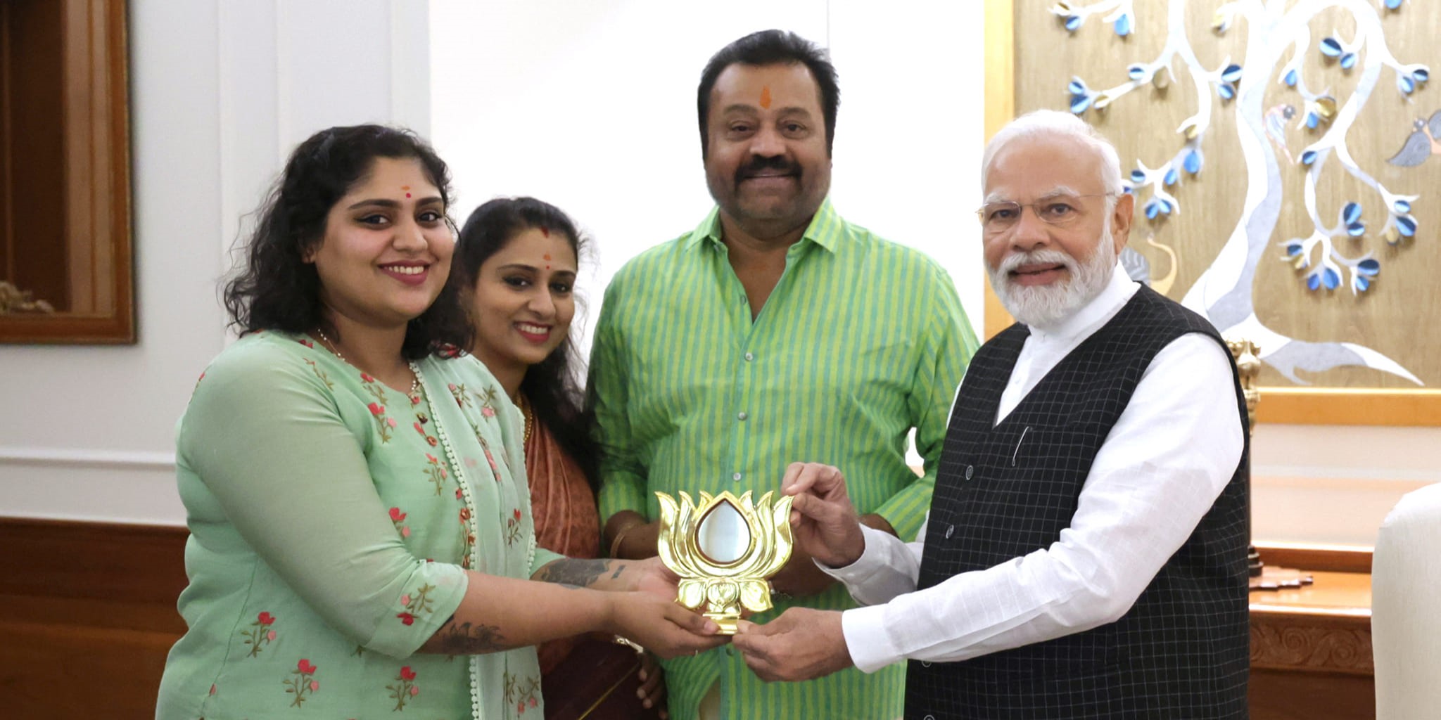 Suresh Gopi with PM Modi Bhagya presents a replica of BJP symbol to Modi in Delhi with Gopi and his wife Radhika Nair.