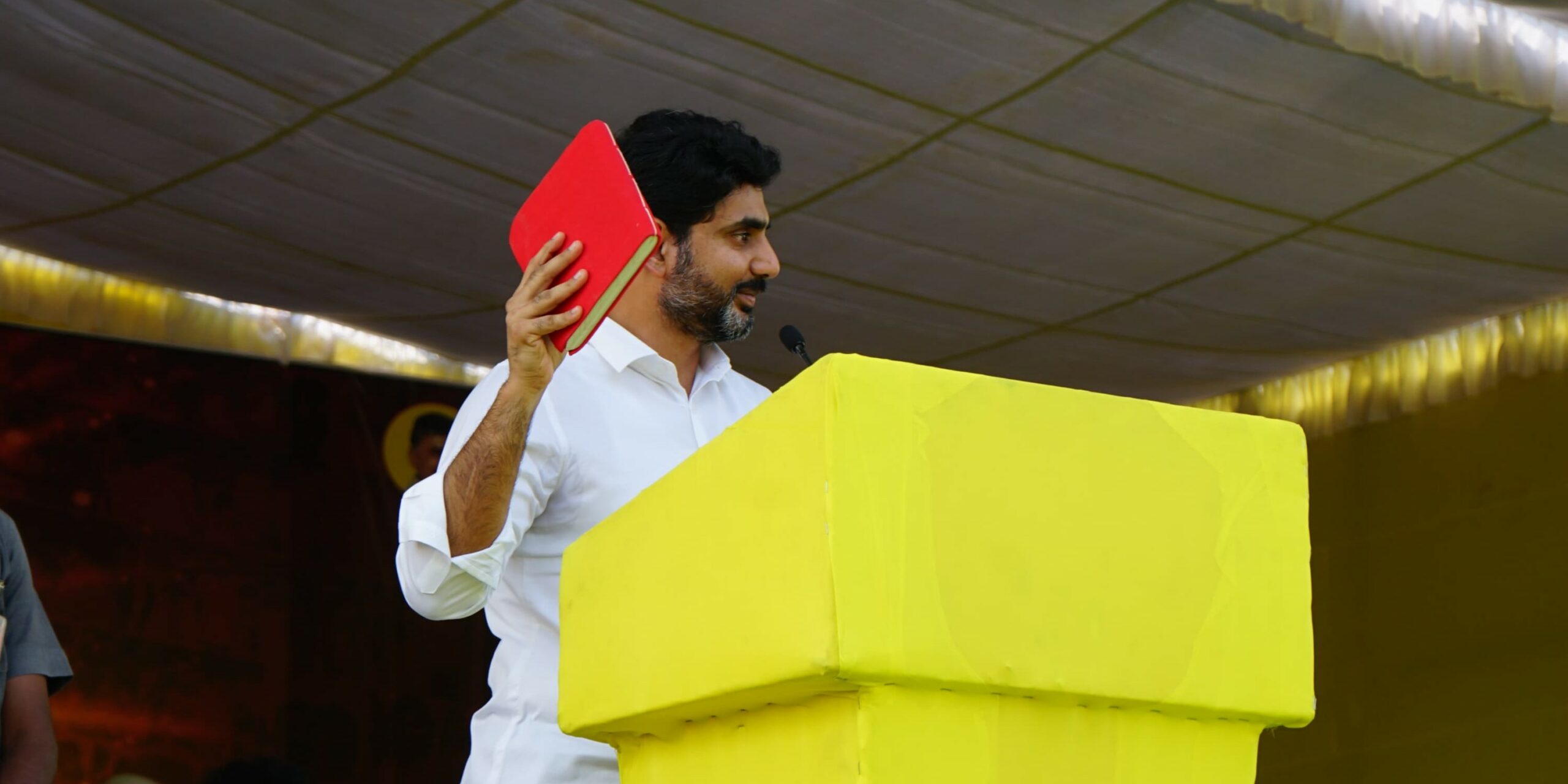 TDP leader Nara Lokesh brandishes the Red Book.