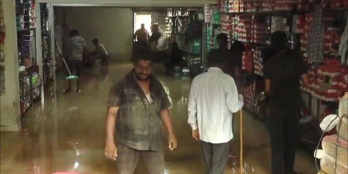 People clearing floodwater from a shop in Coimbatore.