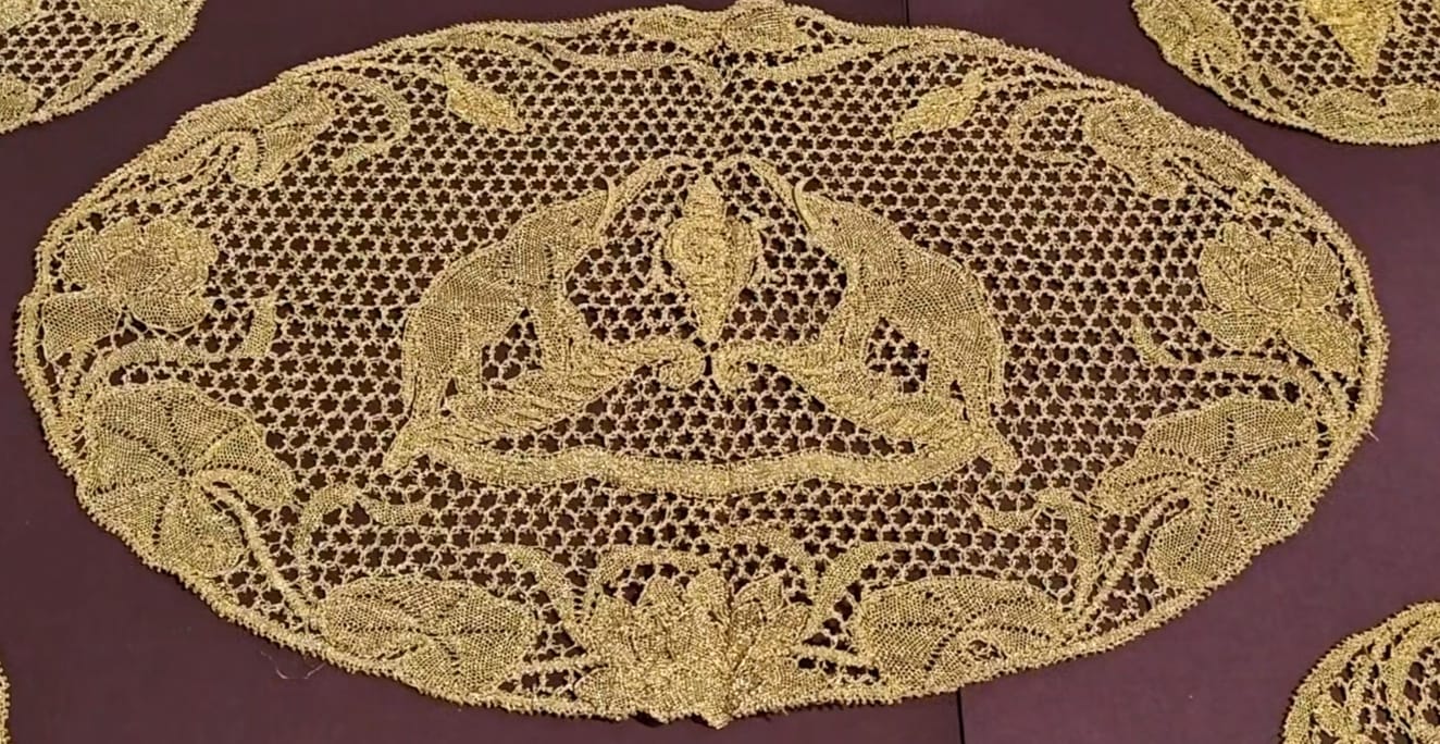 A golden embroidery table mat, depicting Travancore's coat of arms, displayed at BEE 1924.