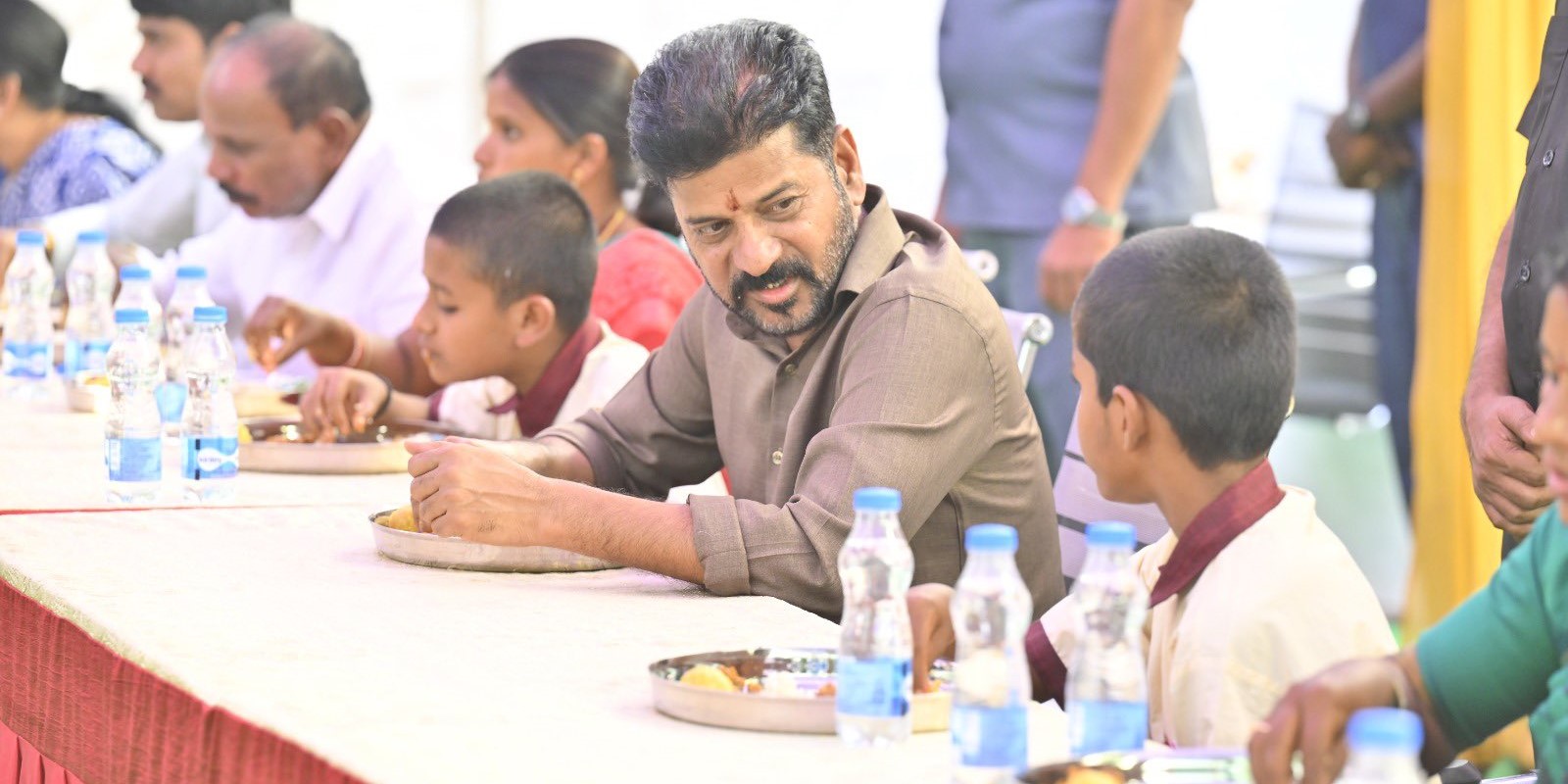 Revanth Reddy having food with school students. Revanth Reddy having food with school students.