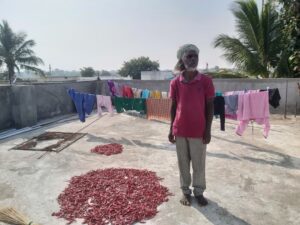 Veeraiah stands next to chillies they have bought from the nearby town of Achampet in order to ground into powder and eat.
