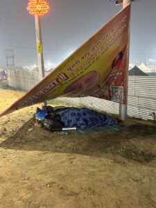 Devotees take shelter under a hoarding