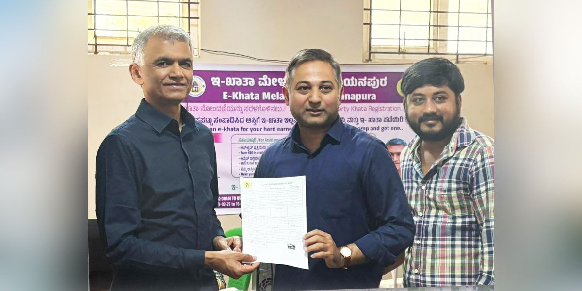 Karnataka Revenue Minister Krishna Byre Gowda handing over an e-Khata document.