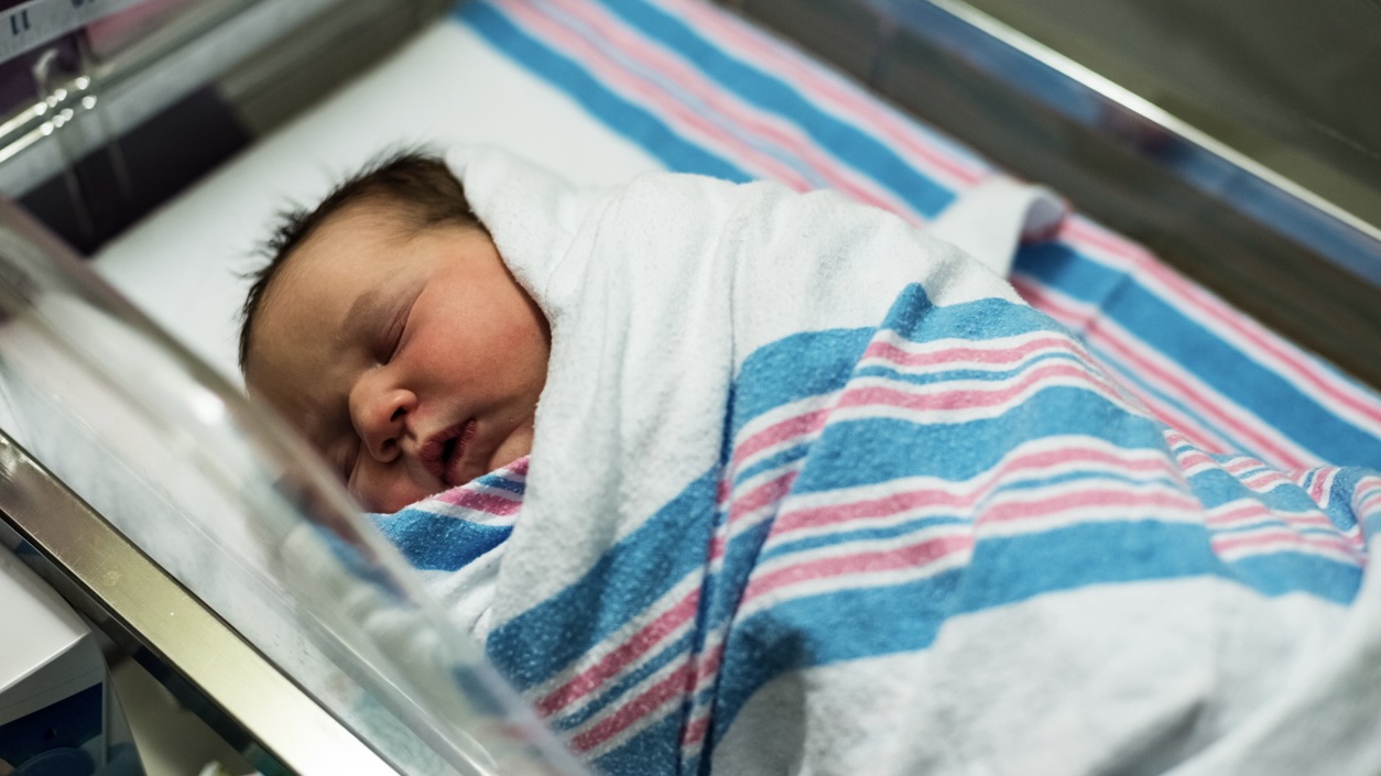 Wrapped tightly in a blanket, a newborn girl sleeps. As India sees more births, southern states record fewer: Tamil Nadu down 21 percent, Kerala 18 percent