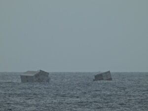 Containers carried by MSC ELSA 3 staying afloat in the sea.