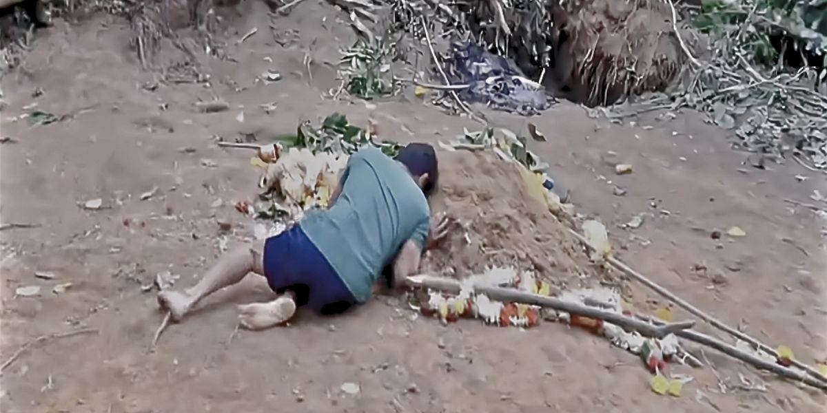 Lakshman lying over his son Bhumik’s grave. Lakshman lying over his son Bhumik's grave.