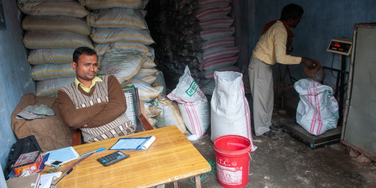 Shopkeeper selling subsidised urea fertiliser at a government-run shop for farmers.