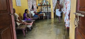 A family in Chellanam waits for the floodwaters in their home to recede.