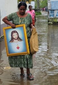 A housewife in Chellanam returns home after the floodwaters recede.