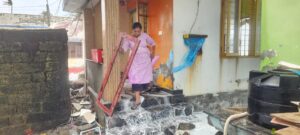 A woman is gathering her belongings from her home in Chellanam.