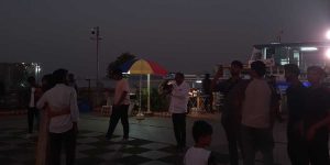 Raju (in white, with a camera) clicks a photo of a couple one late evening.