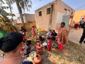 Residents preparing food in front of their demolished homes.
