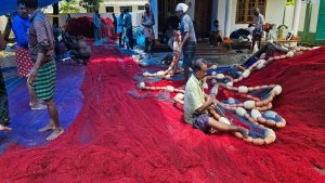 Fisherfolk in Chellanam mending their fishing nets.