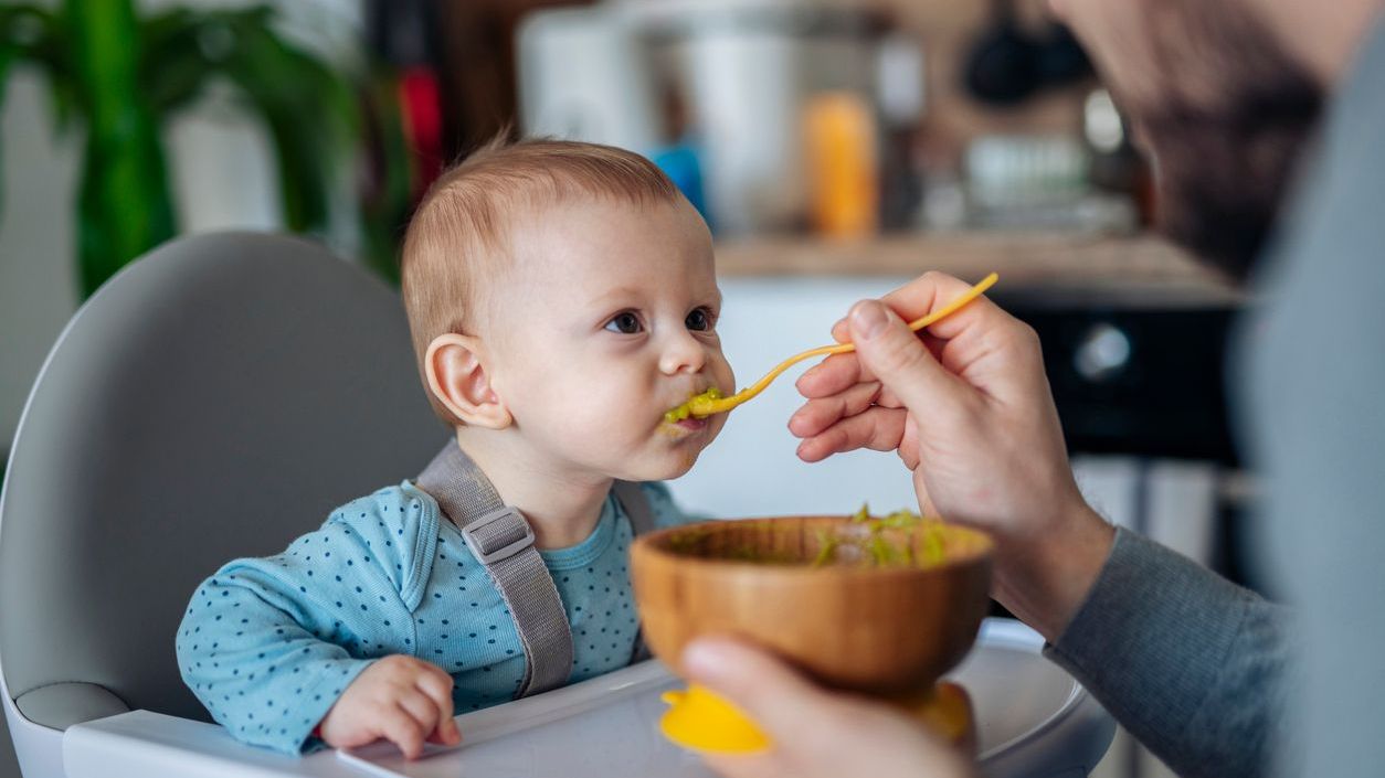 A father spoon feeding his son. (iStock)