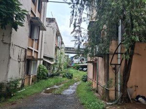 The poor condition of flats in Vasanth Nagar, with the Kochi Metro Rail corridor visible in the background.
