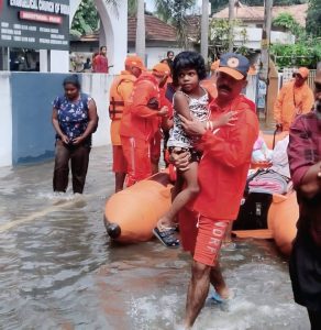 An NDRF personnel member with a child in Alappuzha.